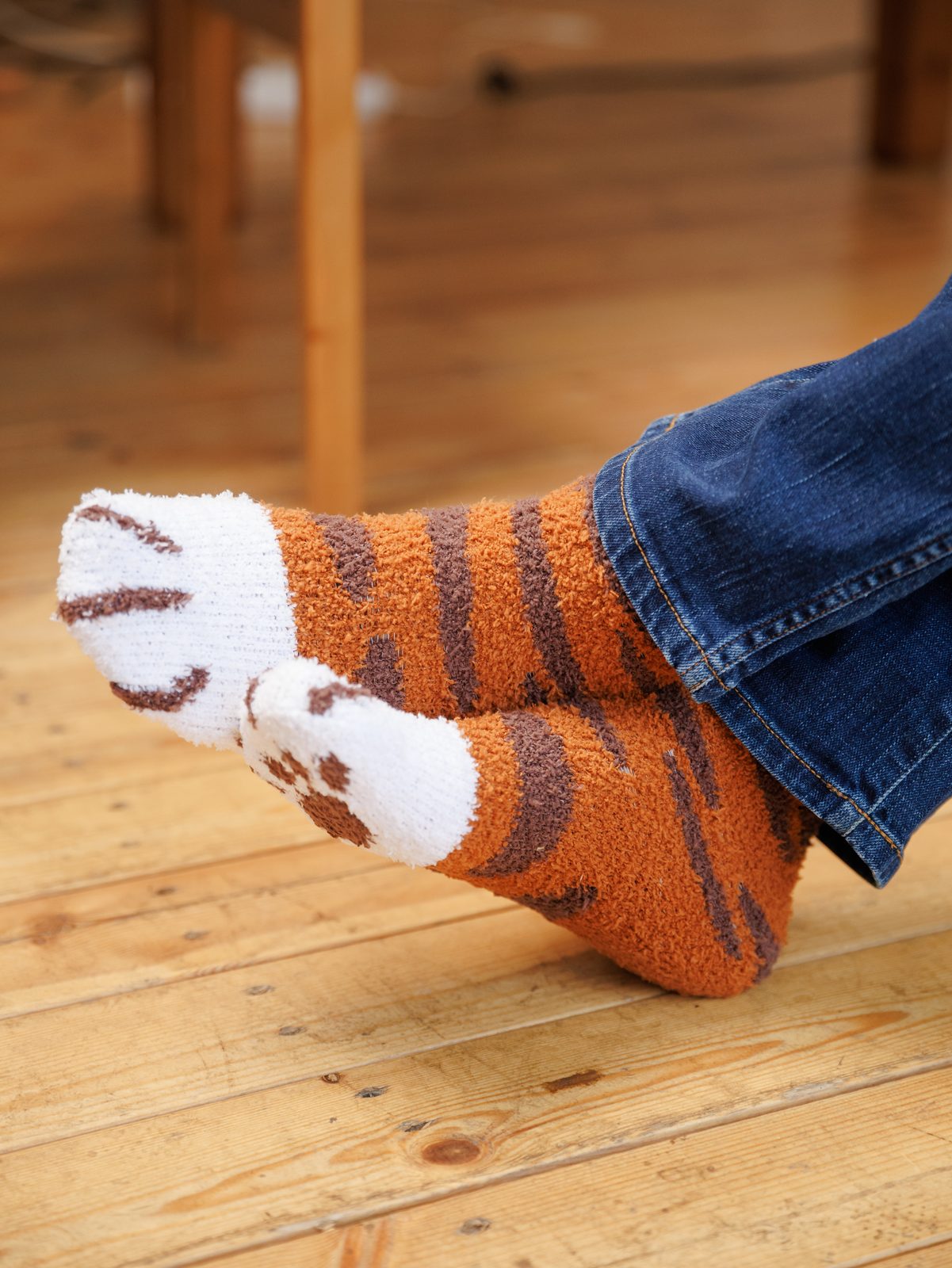 Crossed feet wearing tabby socks, with white toe beans on the soles